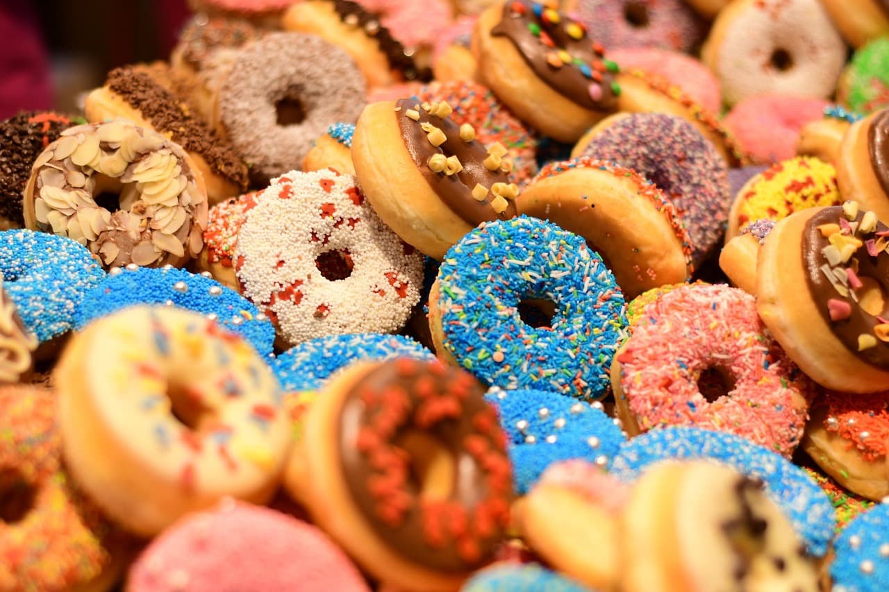 A heap of glazed and sprinkled donuts