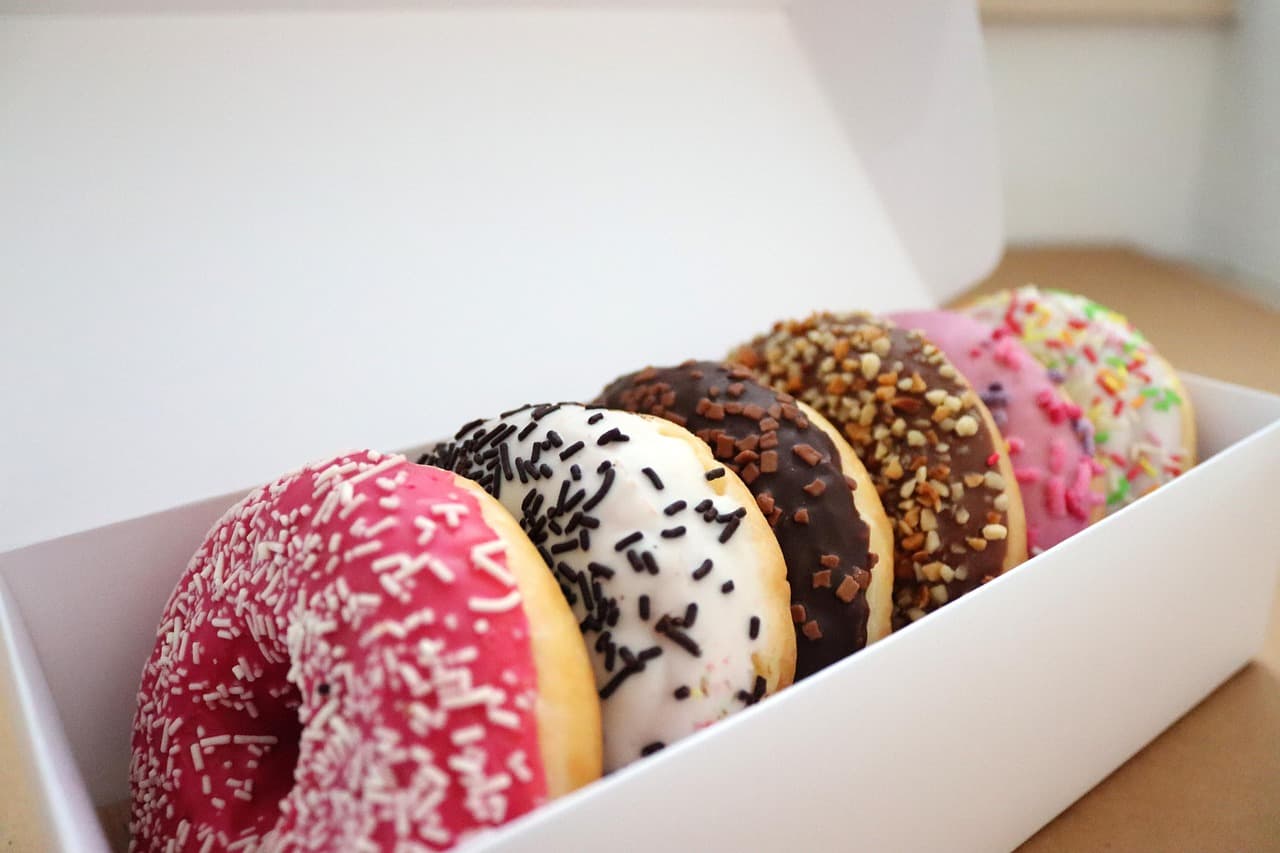 A box of iced donuts with sprinkles